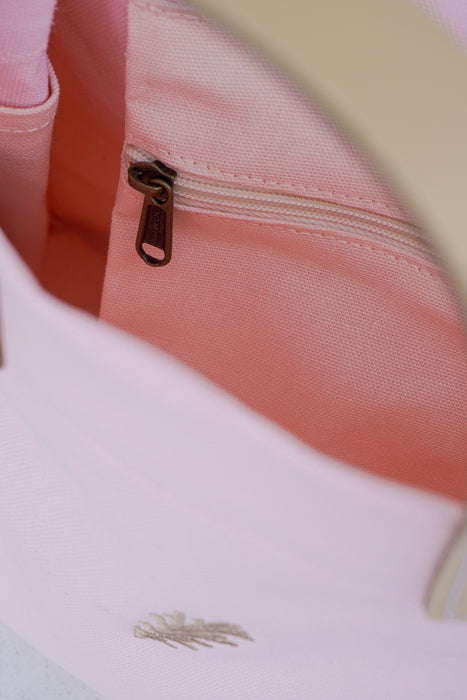 Close-up of a pink bag with a gold zipper.